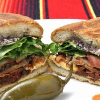 Meat Torta  · Juicy meat  torta with panela cheese, tomato, avocado, jalapeno, onions, and lettuce.