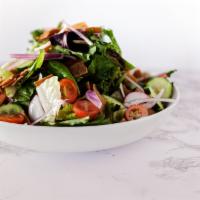 Fattoush · Fresh greens with chopped tomatoes, cucumbers, red onion, radish, mint, pita chips in a pome...