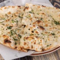 Garlic Naan · Leavened bread with garlic and cilantro cooked in tandoori oven, topped with ghee.
