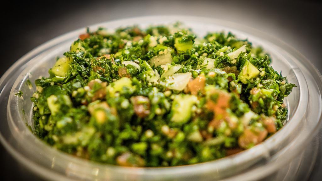 Tabbouleh · Finely Chopped Parsley Mixed with Tomatoes, Onions, Cucumber And Wheat (Bulgur) with Lemon Juice, Olive Oil and Spices.