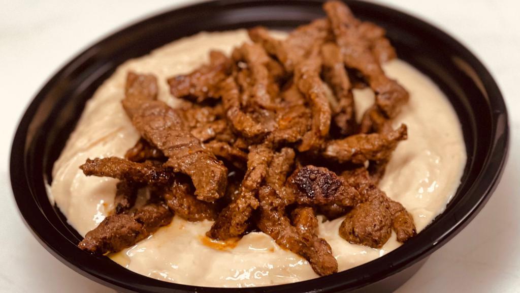 Hummus With Beef Shawarma · Our House Hummus Topped with Our Beef Shawarma, Topped with Olive Oil and Served with Pita Bread.
