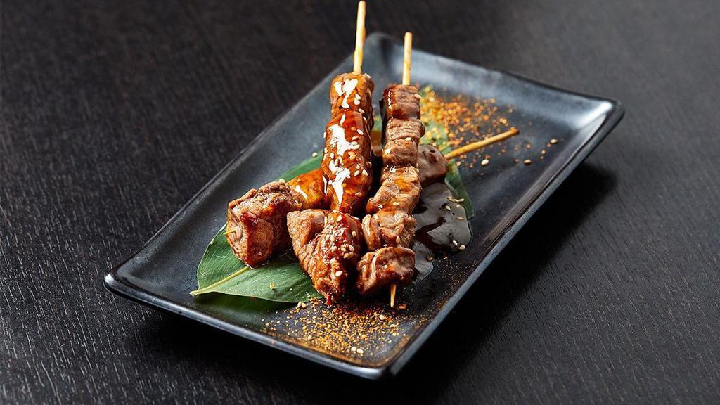 Filet Mignon Skewers · Three skewers of seared filet mignon cooked in sake teriyaki sauce; topped with sesame seeds and togarashi.