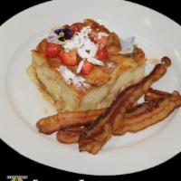 French Toast Souffle · Signature French toast, berries, sliced almonds, powder sugar, choice of meat and syrup.