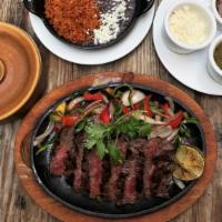Fajitas · sautéed peppers, onions, refried beans, red rice, red & green table salsa, queso fresco, flo...