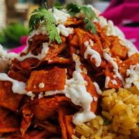 Chilaquiles With Chicken · Crispy corn tortillas dipped in a green or red sauce. Topped with sour cream, and cheese. Se...