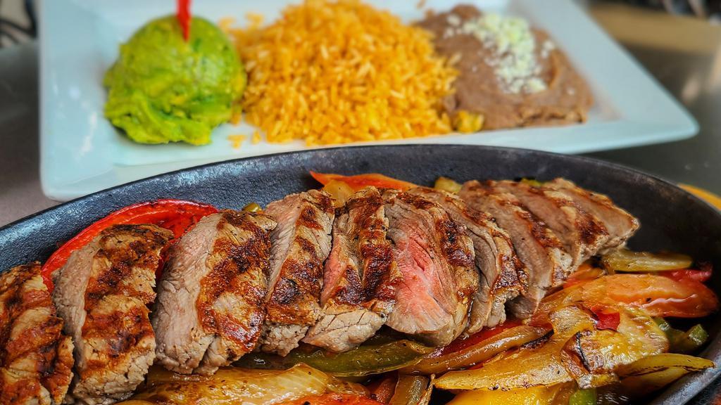 Steak Fajitas · Chef's favorite. Grilled tenderloin strips with sautéed tomatoes, green bell peppers, and onions. Served with rice, refried beans, guacamole, and handmade corn tortillas.