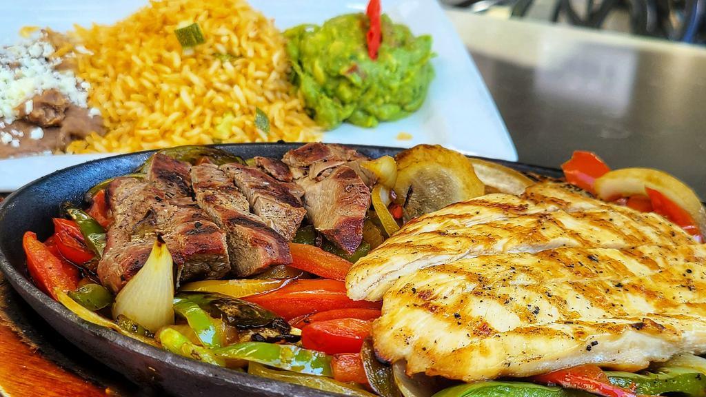 Fajitas Mixta · Grilled chicken and tenderloin strips with sautéed tomatoes, green bell peppers, and onions. Served with rice, refried beans, guacamole, and handmade corn tortillas.