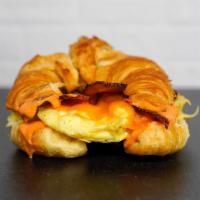 Croissant Bacon, Egg And Cheddar Sandwich · 2 scrambled eggs, melted Cheddar cheese, smoked bacon, and Sriracha aioli on a  warm croissant