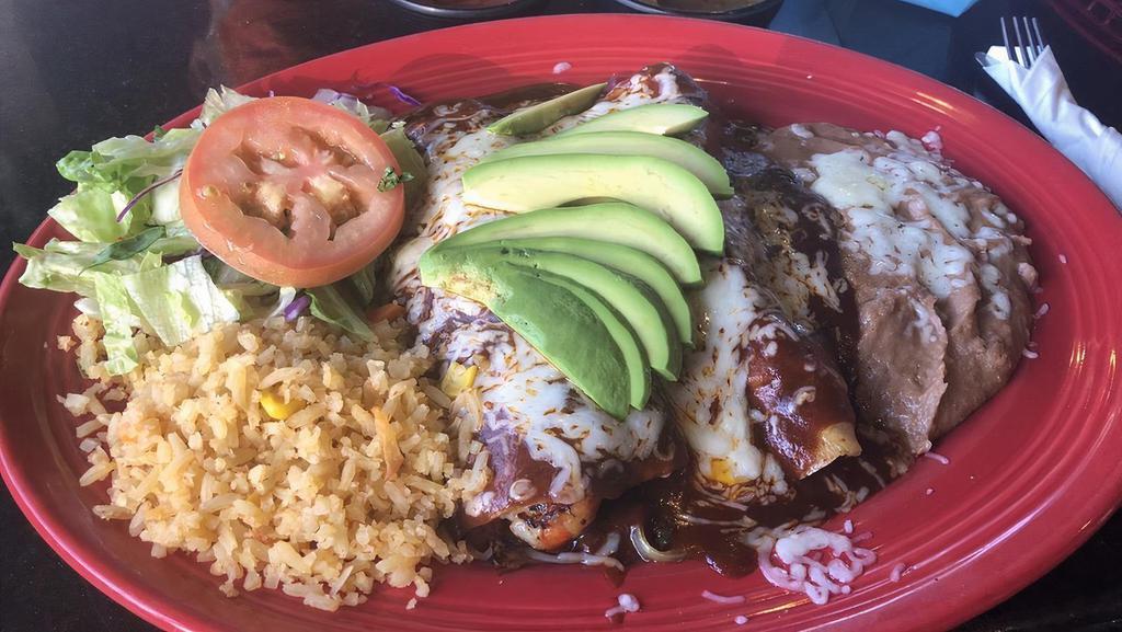Enchiladas Rancheras · 2 red enchiladas, salsa ranchera, 2 over-medium eggs, sour cream, beans.
