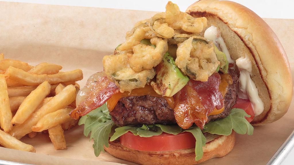 Baecation Burger · Topped with cheddar, crispy applewood smoked bacon, crispy fried jalapeño, sliced tomato and arugula, finished with charred avocado and bacon aioli on a brioche bun.