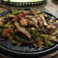 Combo Fajita · Shrimp, beef, and chicken sauteed with onions, bell peppers, tomatoes in our famous seasonin...