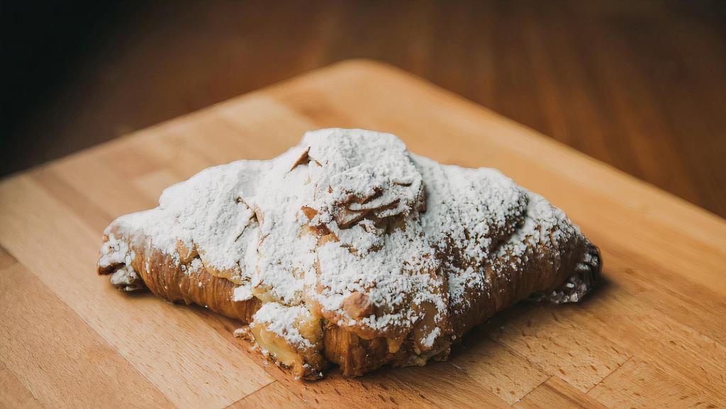 Almond Croissant · Twice-baked butter croissant filled with frangipane and Madagascar vanilla bean simple syrup and topped with sliced almonds.