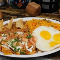 Chilaquiles & Eggs Breakfast · corn tortilla chips with sauted spicy  homemade salsa, sprinkled cotija cheese and 2 eggs on...