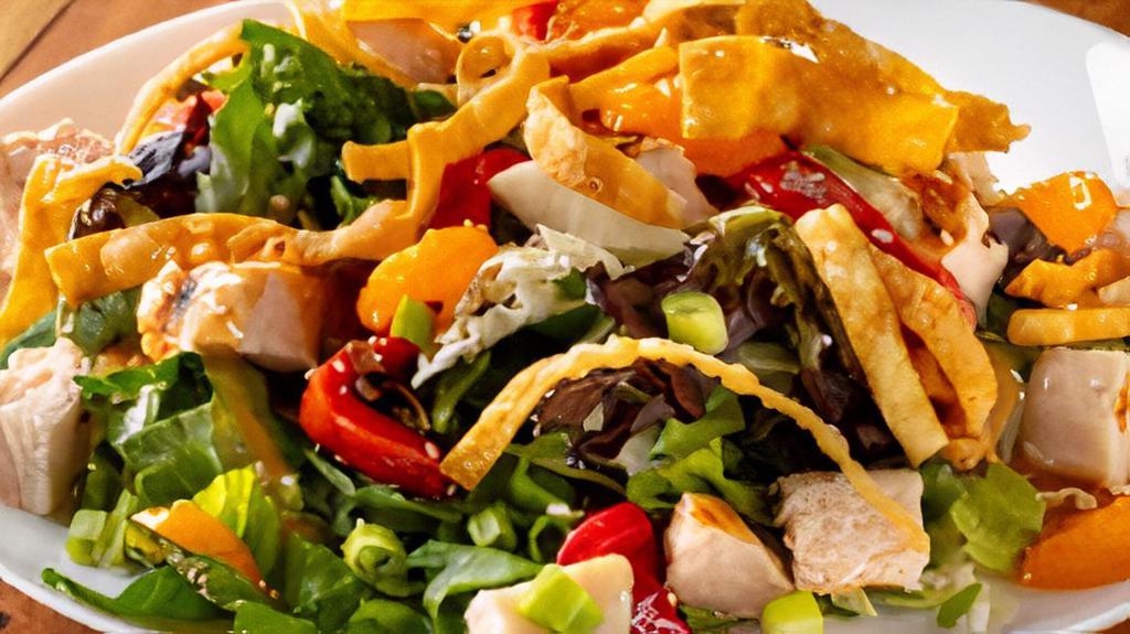 Asian Chicken Salad · A sesame ginger dressing tossed with crisp greens, grilled chicken, roasted red peppers, and green onions. Topped with crispy wonton strips, sesame seeds, and mandarin oranges.