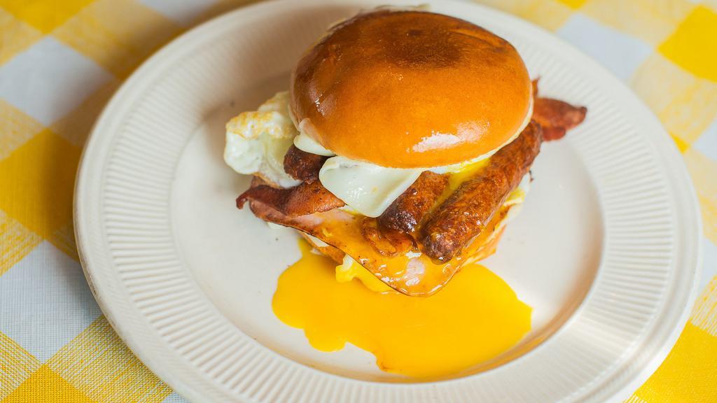 The Big Breakfast Sandwich · Toasted brioche bun with two Eggs, Bacon, Ham, Sausage, Mozzarella, and American Cheese.
