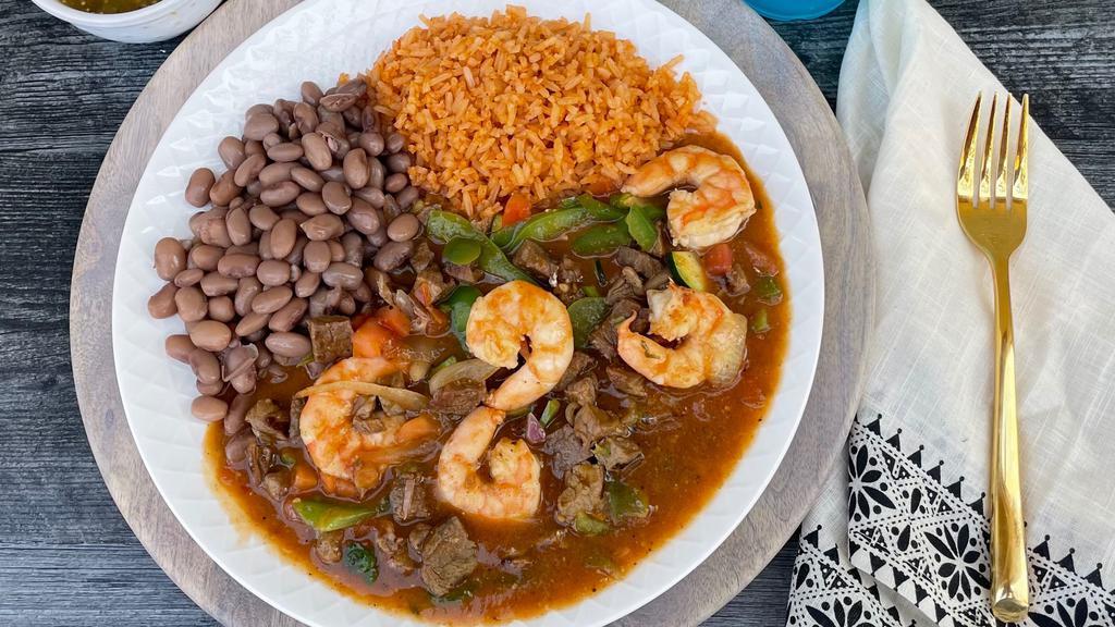 Mar Y Tierra · Fresh cooked shrimp in jalapeño butter & grilled steak, sautéed bell peppers, onions, and pico de gallo mixed in a blend of our homemade sauces.  Served with rice, beans, and your choice of flour or corn tortillas.