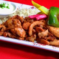 Chicken Shawarma Entree · Marinated chicken breast, thinly carved and grilled, served over  basmati rice, hummus and o...