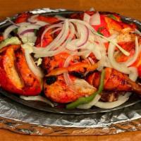 Tandoori Chicken · Chicken marinated in yogurt and spices, cooked over a bed of red hot charcoal in our clay ov...