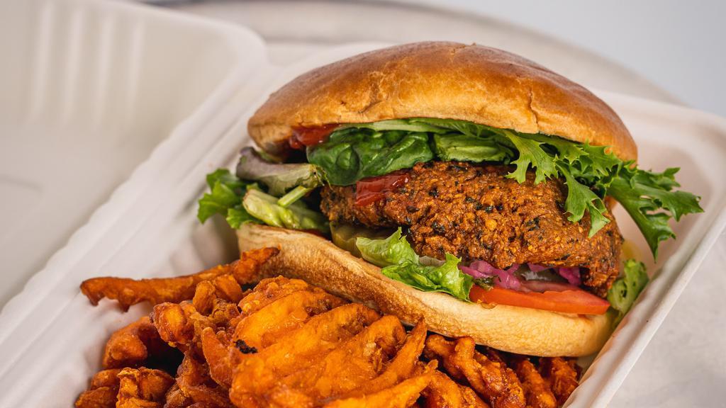 Earth Burger · Vegan. Vegan falafel patty topped with lettuce, tomato, onion, pickles and ketchup, served with a side of sweet potato fries.