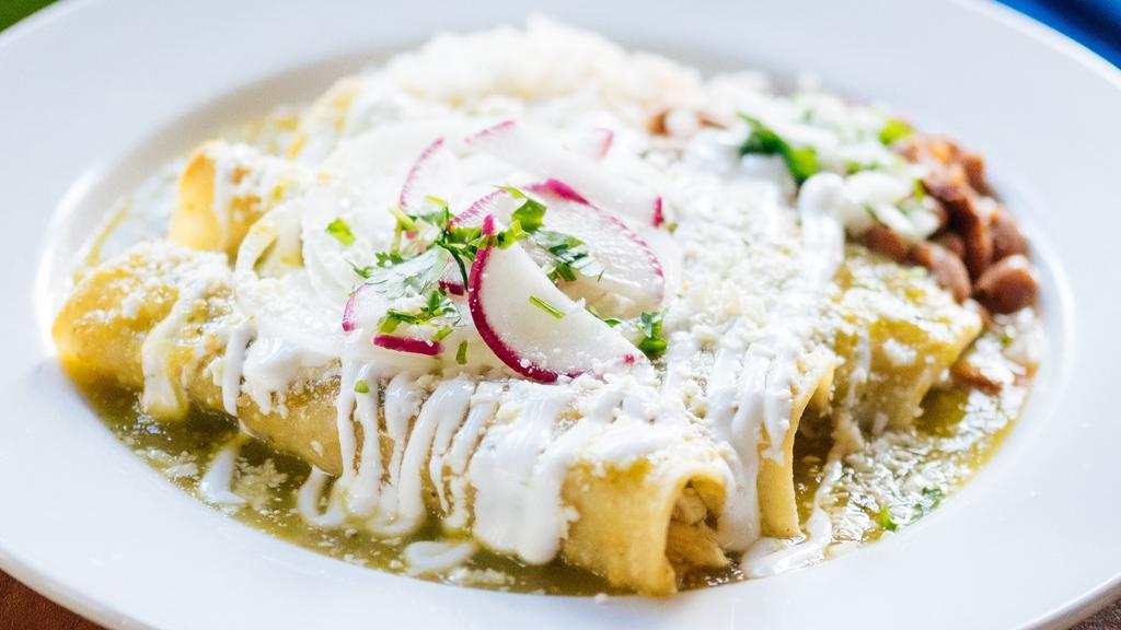 Enchiladas De Pollo · Pulled chicken, tomatillo sauce, radishes, onion, cotija cheese, crema; with steamed rice, whole pinto beans.