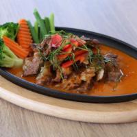 Panang Rib Eye · Grilled well done rib eye topped with panang sauce and kaffir lime leaf.