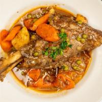 Lamb Shank Platter · Braised and oven-roasted lamb with potatoes, carrots, and peas served over rice.
