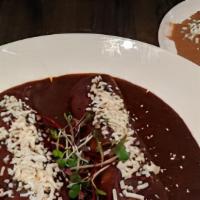 Mole Poblano Chicken Enchiladas · Two soft corn tortillas filled with shredded chicken covered with chile mole poblano sauce a...