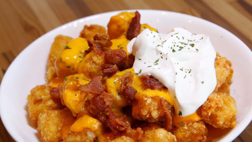 Loaded Cheesy Tater Tots · Smokey cheese sauce, sour cream, and chives with chopped bacon bits.