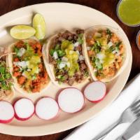 Takos · Meat Tacos topped with Onions Cilantro and Mild Green Salsa