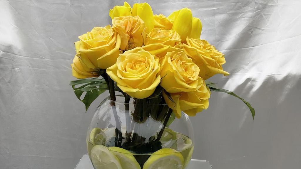 Gorgeous Golden Burst Bouquet · Yellow Roses and Yellow Tulips inside a round glass vase with fresh cut lemons inside