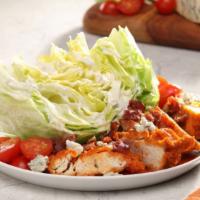 Buffalo Wedge Salad (Grilled) · Buffalo Grilled Chicken tossed with Buffalo sauce over iceberg wedge, tomatoes, bacon, blue ...