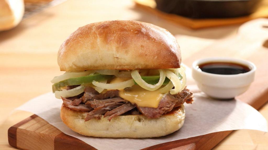 Philly Cheese Braised Beef Sandwich · Braised beef on a Ciabatta bun with American cheese, grilled green pepper & onion strips, served with side of beef au jus.