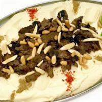 Hummus With Meat · Hummus dip topped with beef shawarma and pine nuts.