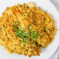 Chicken Biryani · Chicken cooked in basmati rice with chopped green and fried onions.