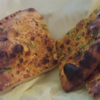 Garlic Naan · Clay oven baked bread topped with garlic and cilantro.