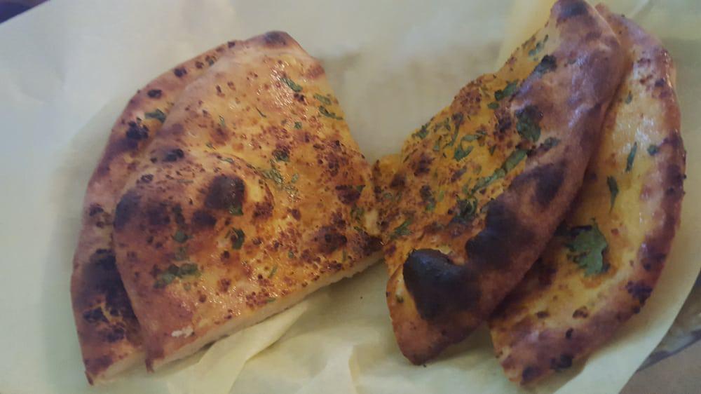 Garlic Naan · Clay oven baked bread topped with garlic and cilantro.