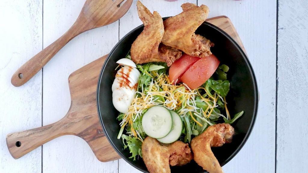 Wing Salad · Four fried chicken wings, atop a mix of fresh salad greens, tomatoes, carrots, hard-boiled egg, cucumbers and shredded cheese. Served with dressing of your choice.