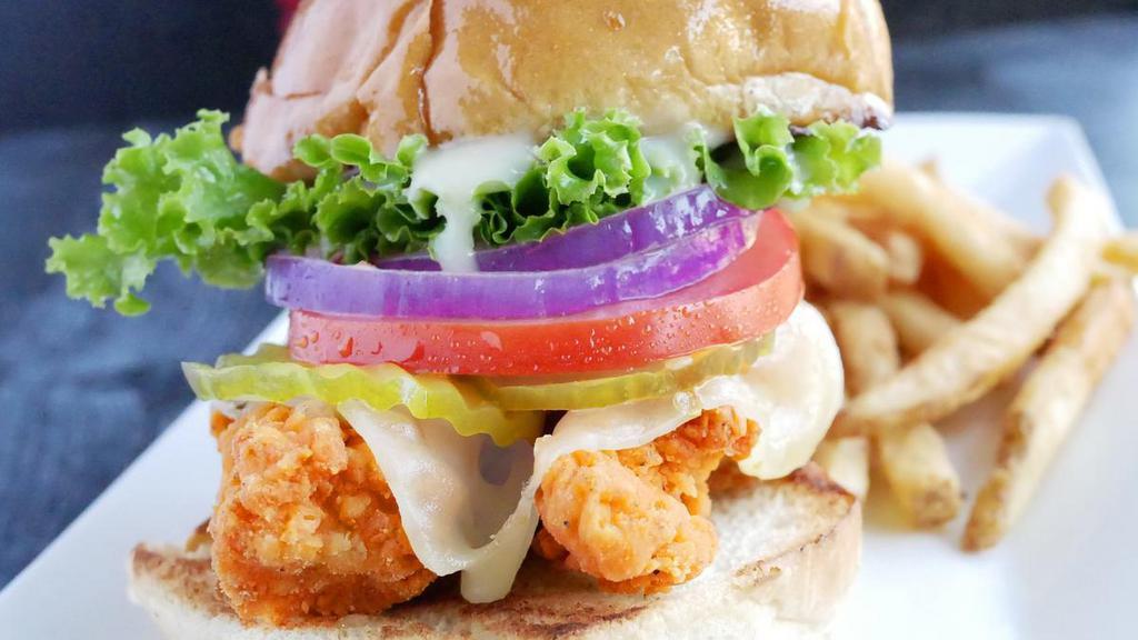 Crispy Chicken Sandwich · Two crispy breaded chicken breast, with lettuce, tomatoes, pickles, onions, mayo and Pepper Jack cheese. Served on a Brioche Bun W/French fries.