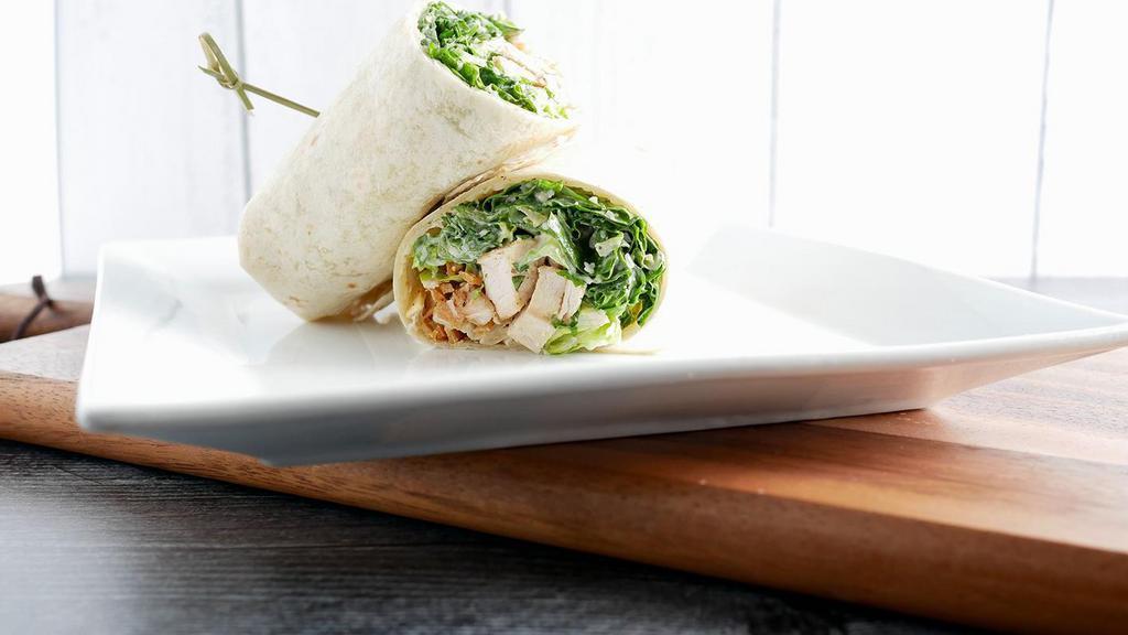 Chicken Caesar Wrap · Grilled marinated chicken breast, chopped romaine lettuce, fried tortilla strips, shredded parmesan cheese tossed in caesar dressing, wrapped in a flour tortilla.