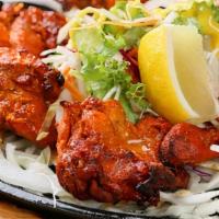 Grilled Chicken Tikka · Boneless chicken coated in a special yogurt marinade served with onions and green peppers on...