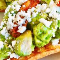 Avocado Con Toast · Toasted ciabatta topped with crushed avocado, EVO Verde, roasted tomatoes, basil and goat ch...