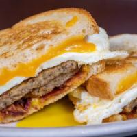 Breakfast Sandwich · Three eggs any style, cheddar cheese, bacon and two sausage patties on choice of sourdough t...