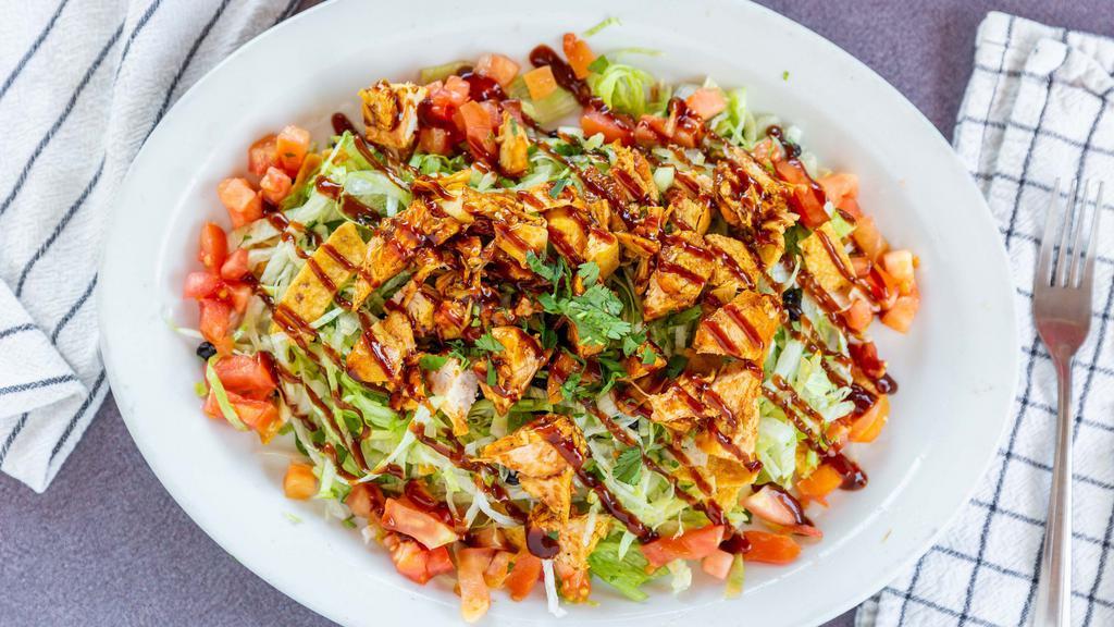 Bbq Chicken Salad · Shredded iceberg lettuce, onion, cilantro, tomato, Frito lay chips, black beans, corn, chopped chicken breast with BBQ sauce, and ranch dressing on the side.
