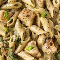 Chicken Pesto Pasta · Chicken breast over a bed of penne pasta topped with house made pesto cream sauce and Parmes...
