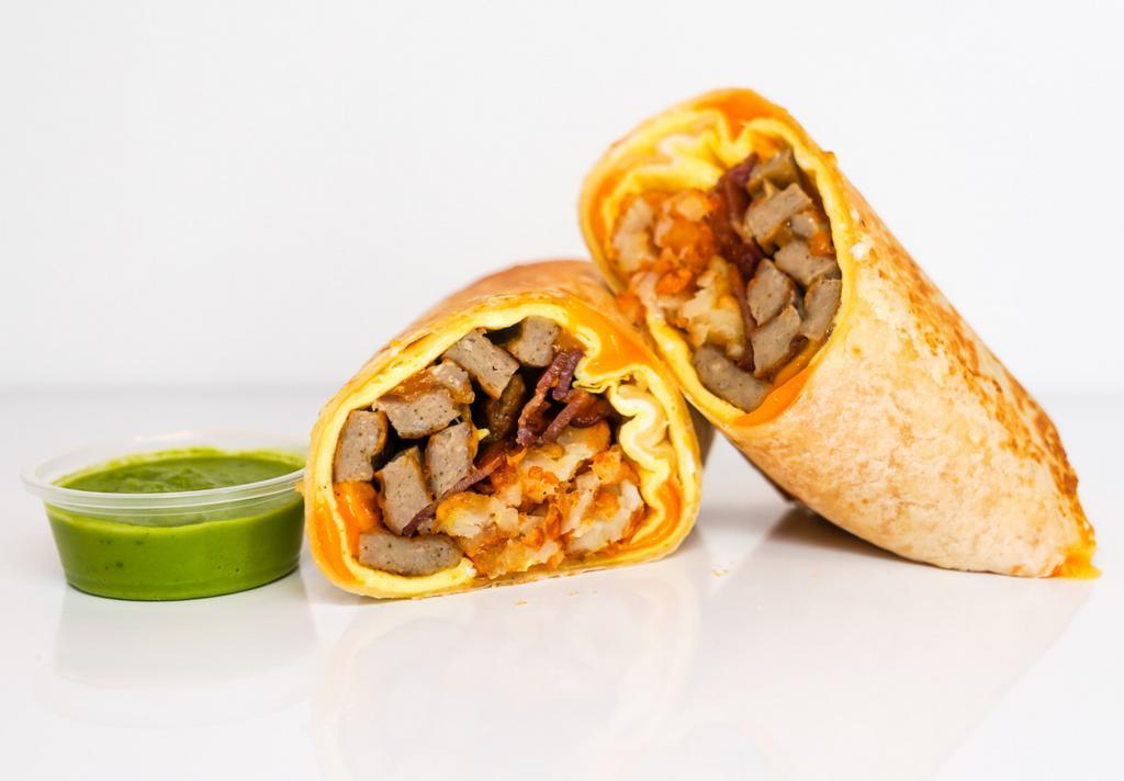 Bacon, Sausage, Egg & Cheddar Breakfast Burrito · 3 fresh cracked, cage-free scrambled eggs, melted Cheddar cheese, smokey bacon, pork sausage, and crispy potato tots wrapped in a toasted 12” flour tortilla. Comes with avocado salsa verde side.