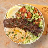 Beef Kebab Rice Bowl · Ground beef over white rice with hummus, diced cucumber and tomato salad, shredded green cab...