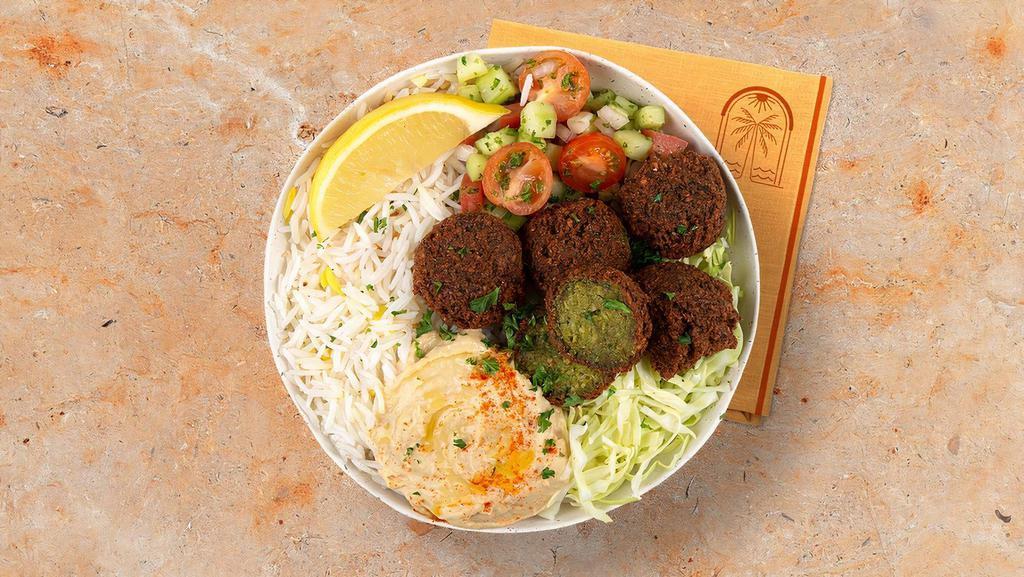 Falafel Rice Bowl · Crispy falafel over basmati rice with hummus, diced cucumber and tomato salad, shredded green cabbage and a drizzle of tahini sauce.