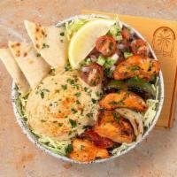 Chicken Kebab Hummus Bowl · Grilled chicken over hummus, Greek salad, shredded green cabbage and a drizzle of tahini sau...
