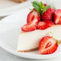 Strawberry Cheesecake · A silky NY cheesecake crowned with fresh strawberries on top of a sponge cake base.