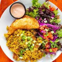 Lazy Rice · A delicious Caribbean rice with bacon and ground beef served with empanada and salad.